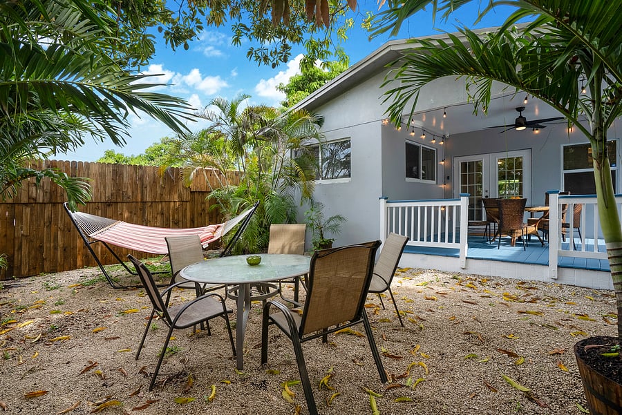 Secluded backyard under a huge mango tree and a covered deck.