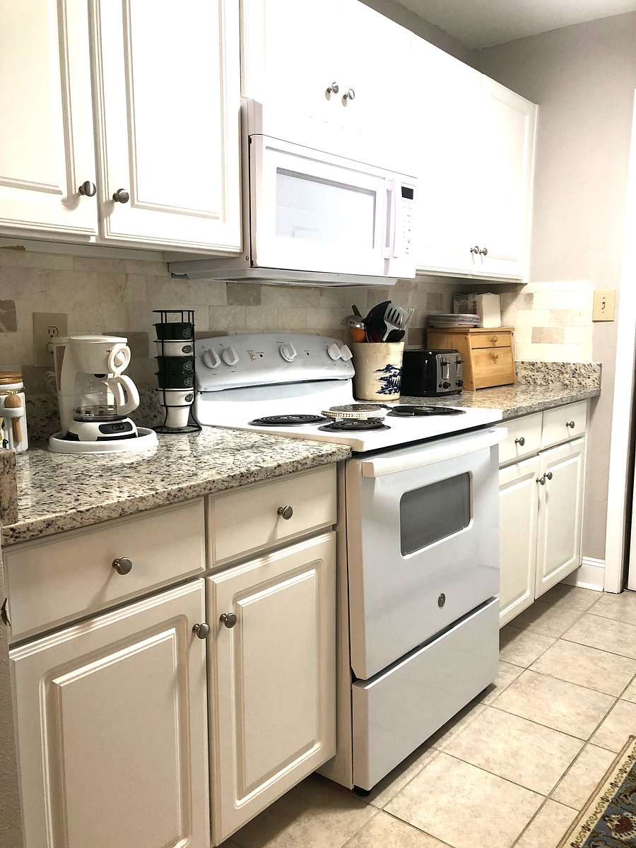 KITCHEN WITH THE ESSENTIALS, SUGAR, SPICES, COFFEE, GLASS AND DISHWARE, DISPOSABEL DISHWARE, MOST EVERYTHING DOWN TO THE PARCHMENT PAPER.