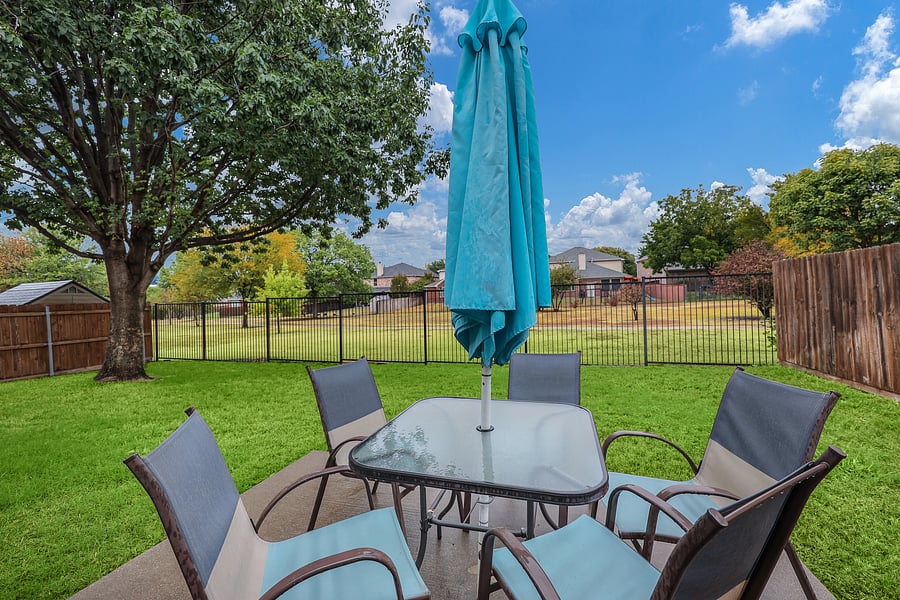 Private fenced backyard with furnished patio, umbrella and grill, backing to neighborhood green space and a walking/running trail.