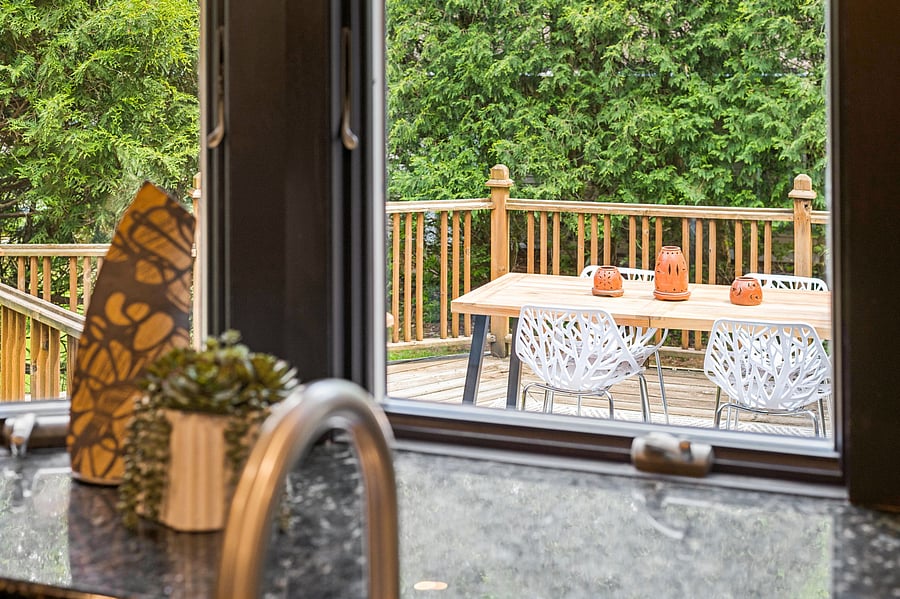 Sunny kitchen window looks directly out onto the deck and back porch with plenty of room for entertaining.