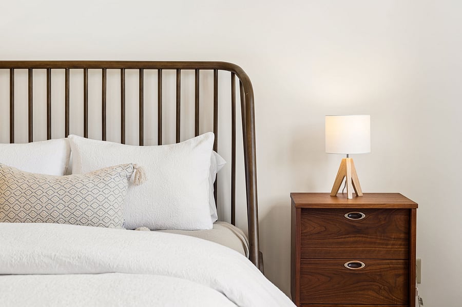 Queen bed with brand-new memory foam mattress and premium linens. Restored midcentury side tables for storage and easy outlet access.