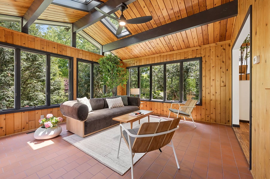 Three walls of windows and two skylights bring in the great outdoors. Surrounded with green trees yet perfectly secluded and cozy, the space feels like you're floating in a treehouse.