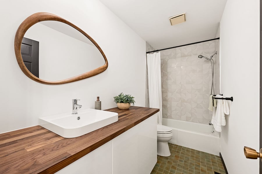 The recently updated second full bathroom features a large vanity, bathtub and shower.