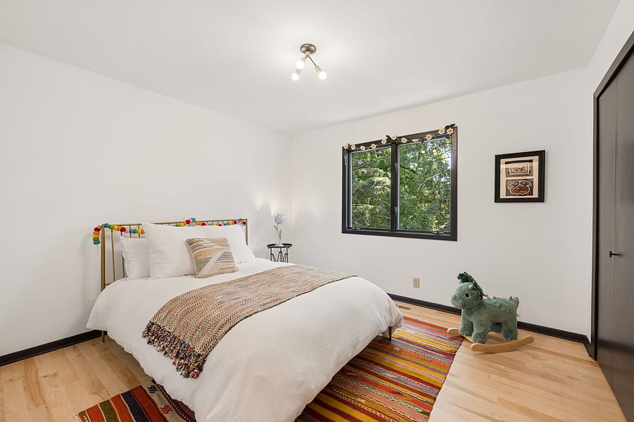 The second bedroom, just down the hall from the primary bedroom. Refinished maple floors and forest views. A second full bathroom with tub and shower is just across the hallway.