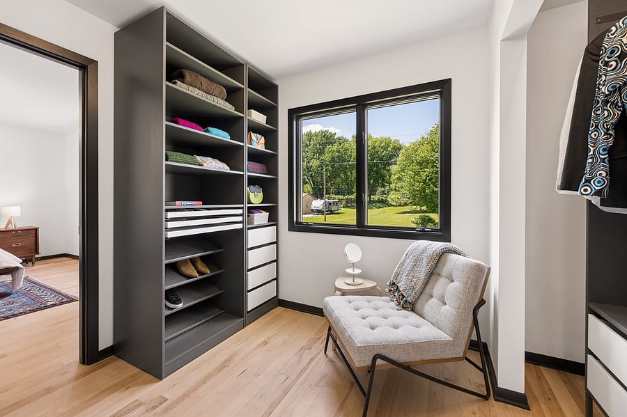 The primary bedroom's large ensuite walk-in closet includes built in dressers, cabinetry, and a mix of open and drawer storage for folded clothes, shoes, and adornments. Connects directly to the private primary bathroom.