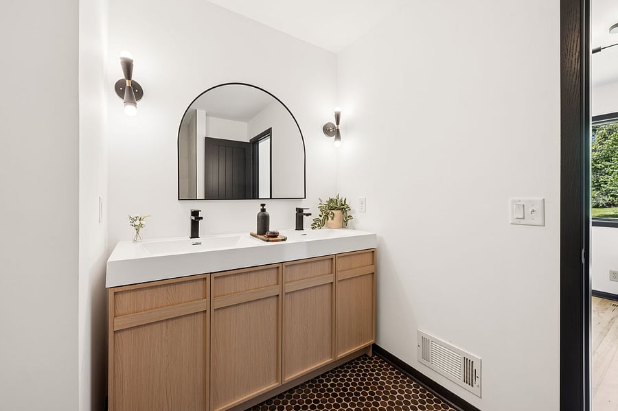 The updated and remodeled primary ensuite bathroom features a double vanity with two sinks and plenty of storage for toiletries and more.