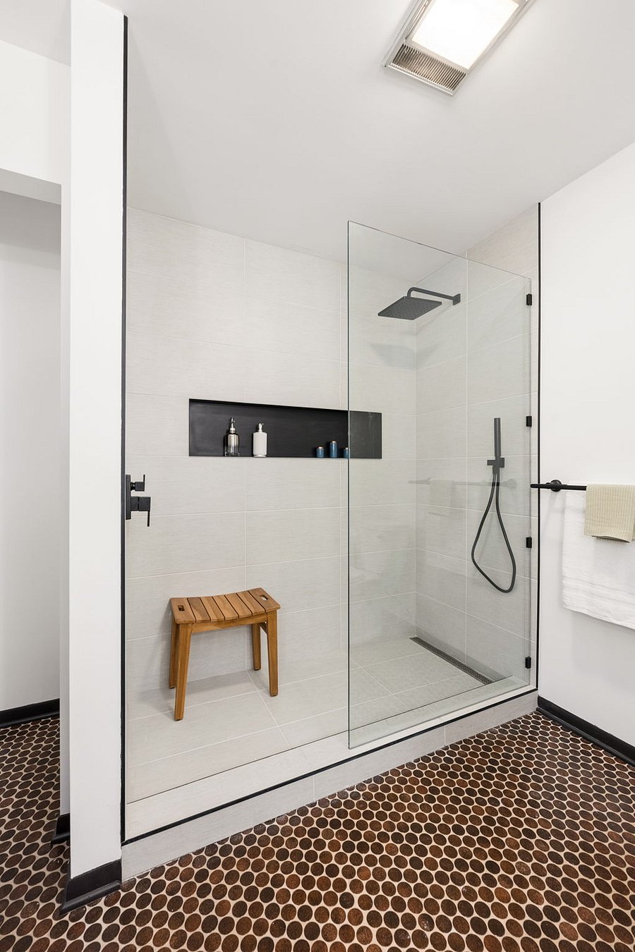 The updated and remodeled primary ensuite bathroom features a large walk-in shower with rain head shower head and imported Italian anti-microbial tile.