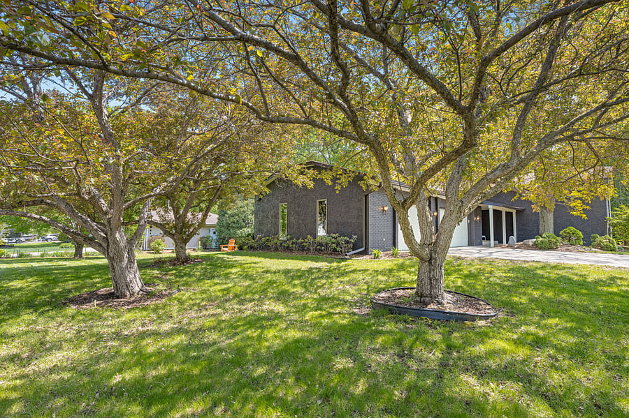 Nearly half-acre wooded corner lot with mature trees, a back deck, refreshed cedar paneling, and quiet privacy.