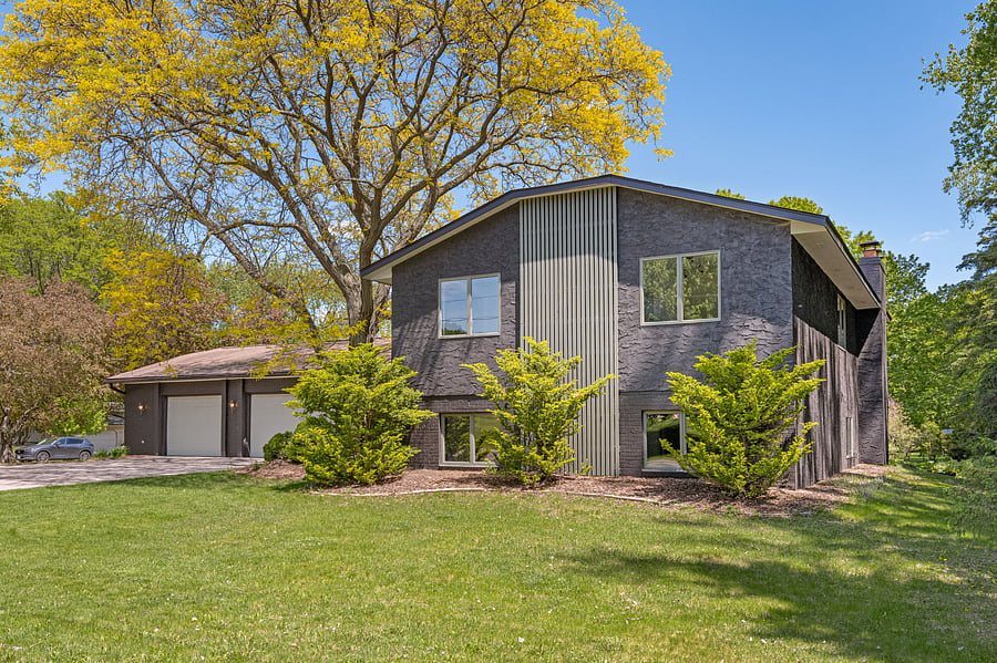 Nearly half-acre wooded corner lot with mature trees, a back deck, refreshed cedar paneling, and quiet privacy.
