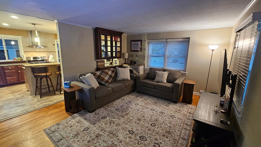 Central living area with large TV adjacent to kitchen area, shared use.