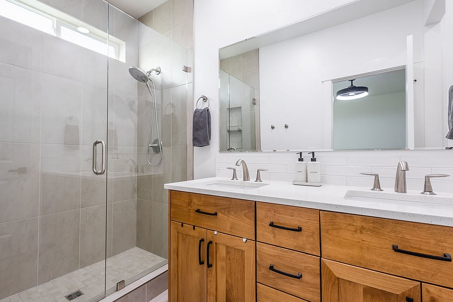 Walk in tiled shower, quartz countertops, double sink.
