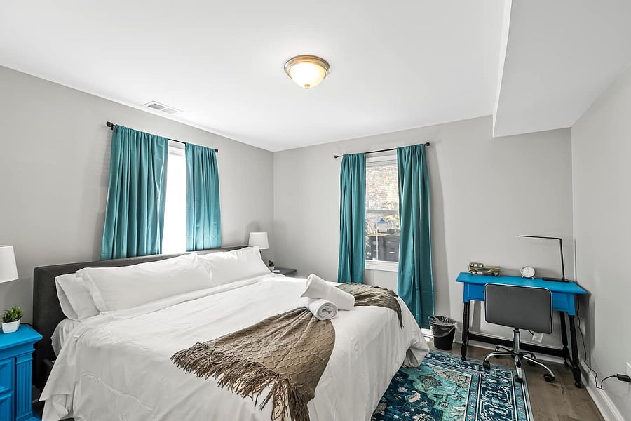Relax in the master with a King mattress, luxurious bedding, full-length mirror, desk/workspace, nightstands with charging ports, closets, and blackout curtains for restful nights!