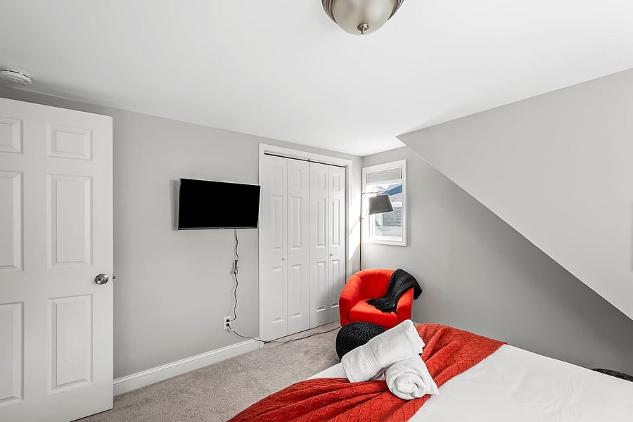 Sleep well in a Queen bed with premium bedding, accent seating, full-length mirror, nightstands, closet, blackout curtains, and smart TV.