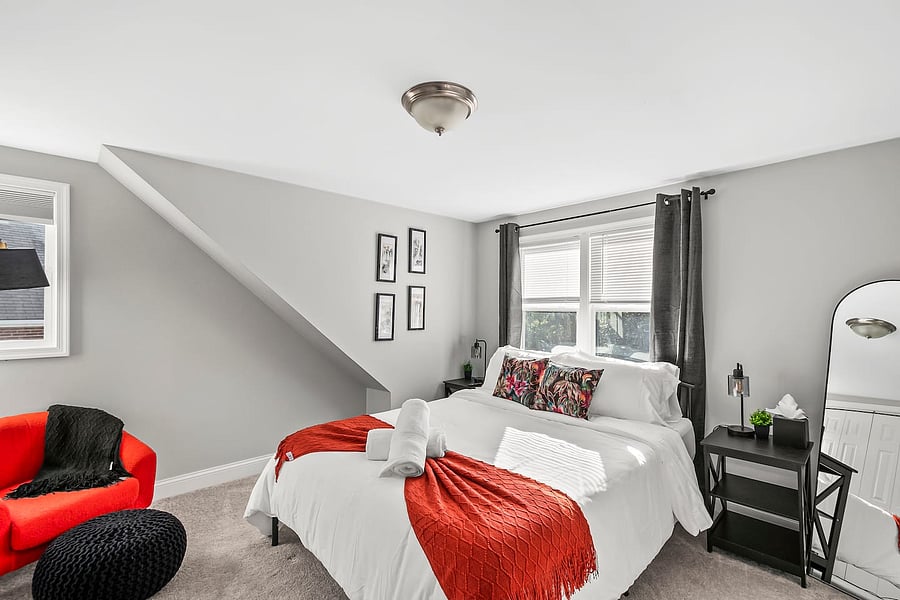 Bedroom retreat: Queen bed, comfy chairs & Ottoman, mirrors, nightstands, closet, blackout curtains, and smart TV for perfect rest.
