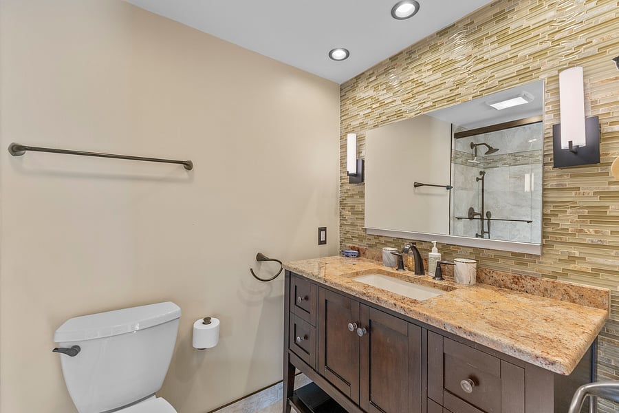 Bathroom 1 vanity with a large mirror and granite countertop
