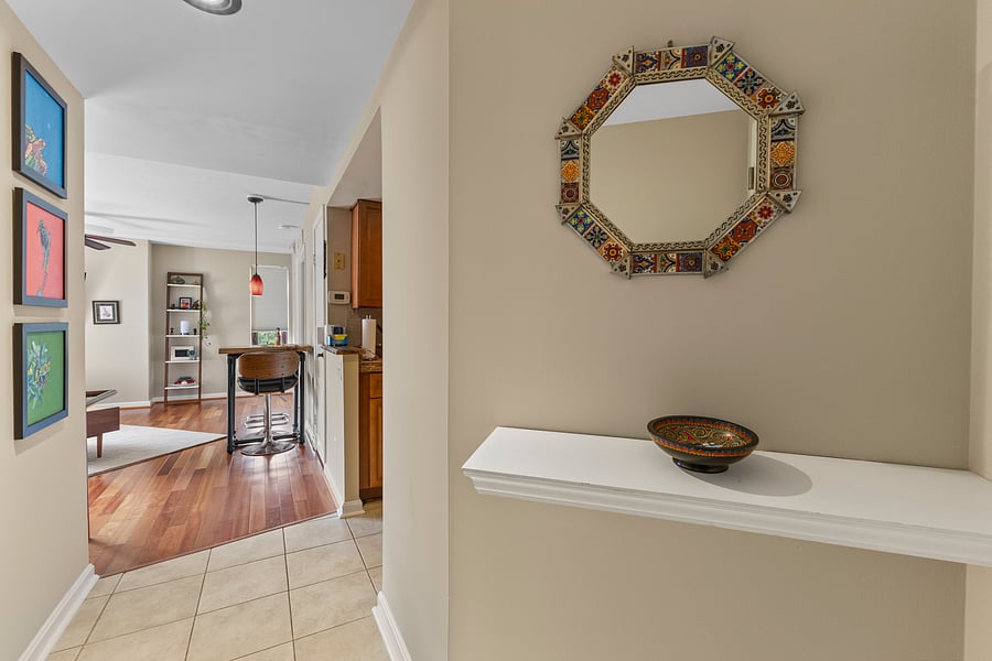 Entryway with a decorative mirror and accent shelf