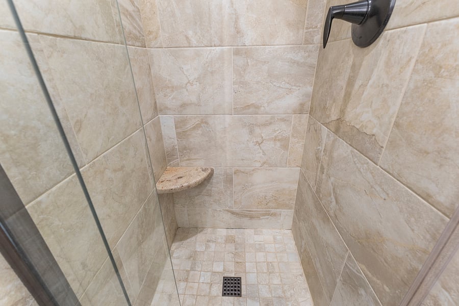 Tiled walk-in shower with a built-in corner seat