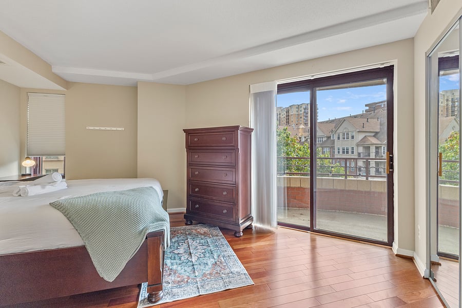 Bedroom 2 with a large dresser and sliding doors to the private balcony