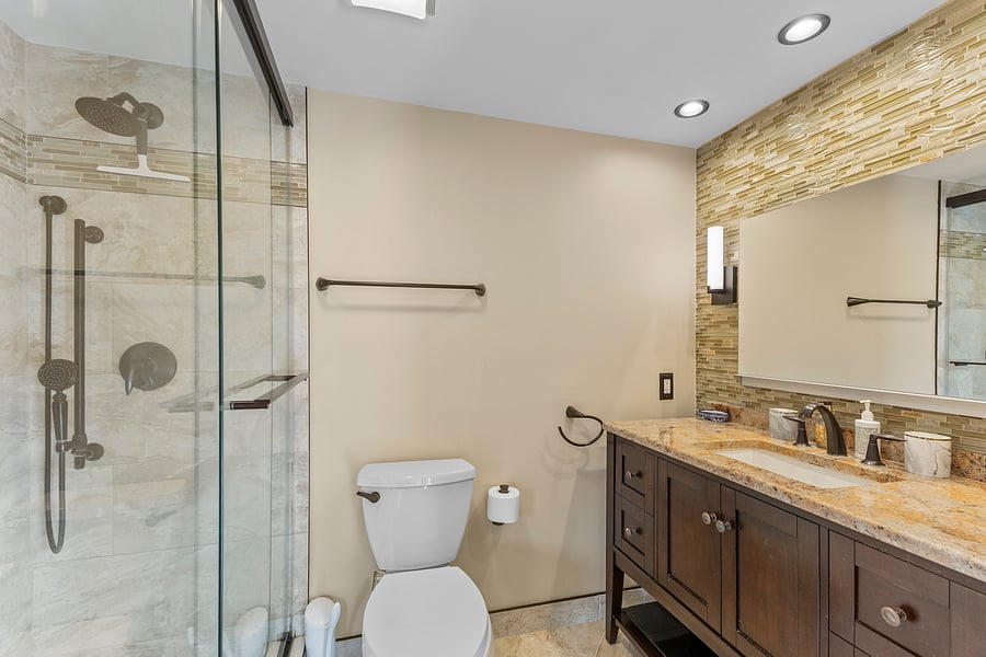 Bathroom 1 with a granite vanity and glass walk-in shower