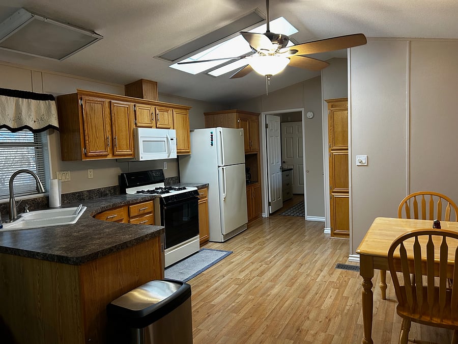 Furnished kitchen with gas stove, dishwasher, and microwave. The coffee maker and cookware are in the cupboards.