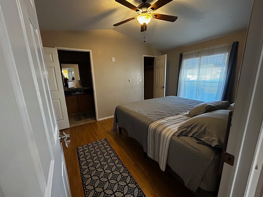 Master bedroom with a walk-in closet and its own full bath. Windows have blinds and room-darkening curtains.