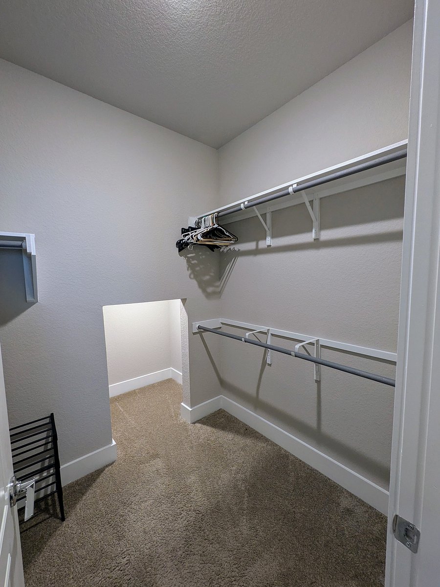 Primary closet with plenty of space and small storage nook