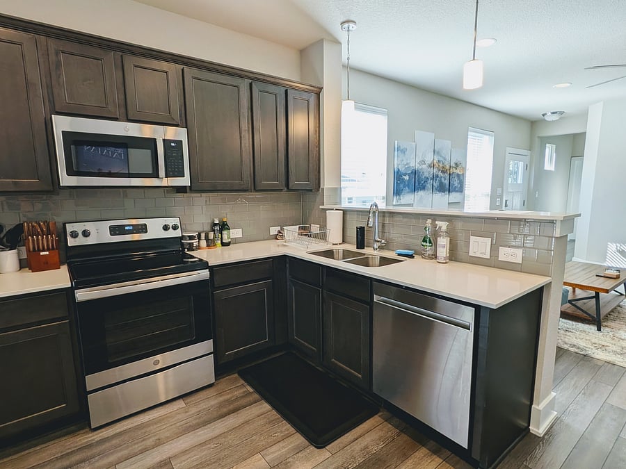 Microwave, electric range, and dishwasher in open kitchen