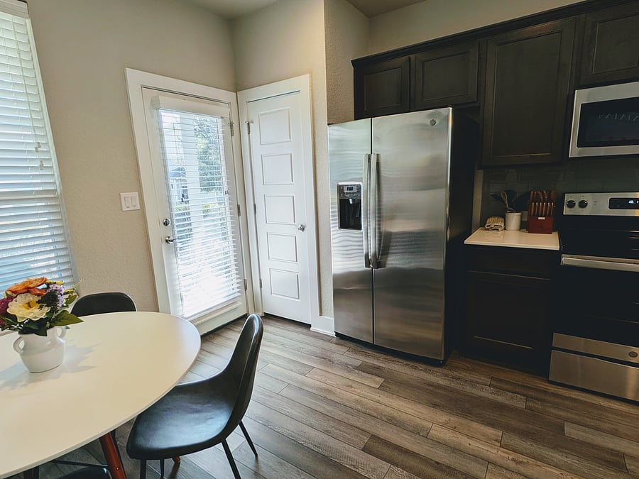 Pantry door to left of the fridge, exterior door opens to covered patio