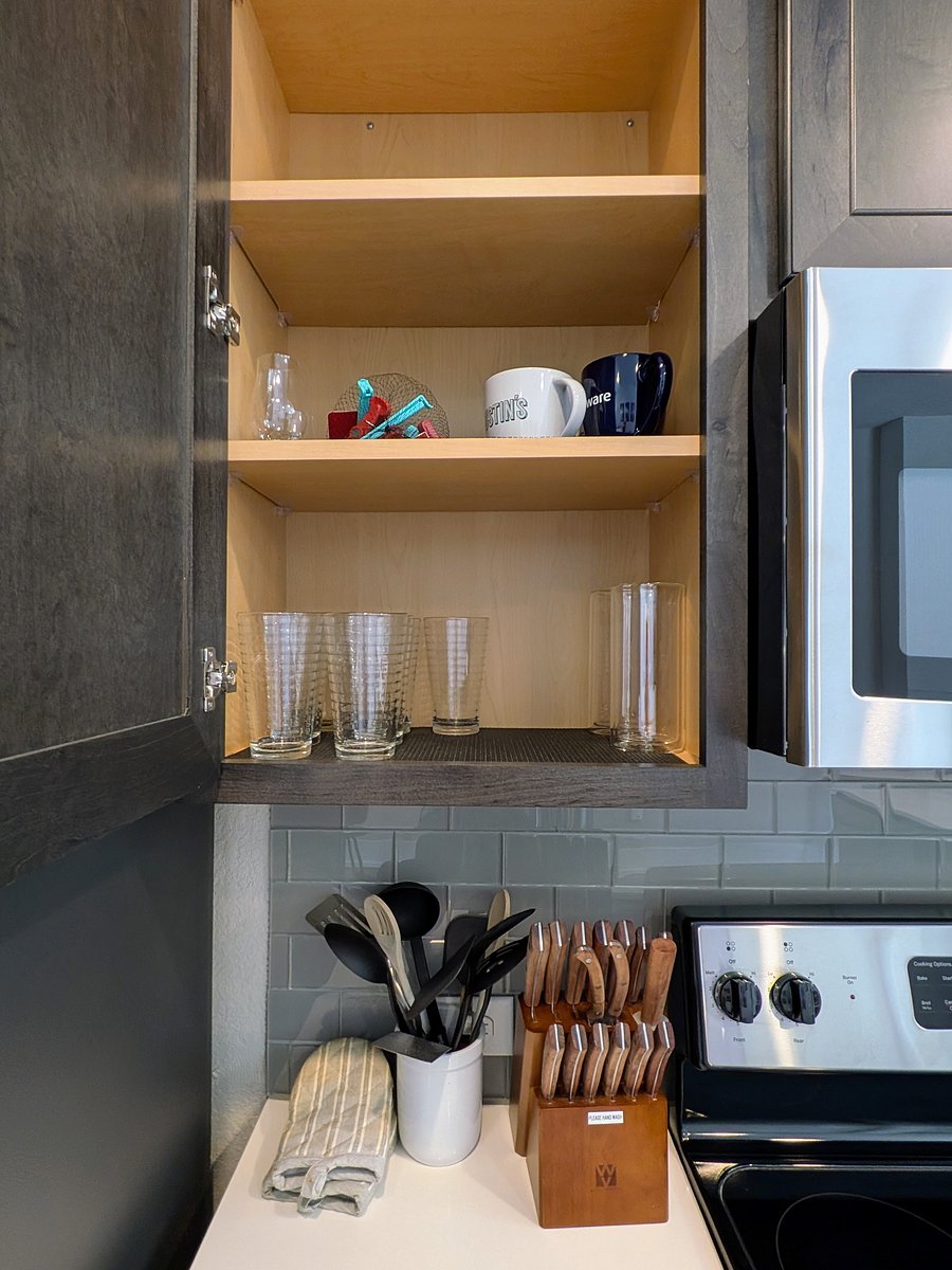 Glassware and mugs in the cabinet, utensils and high quality knives on the counter
