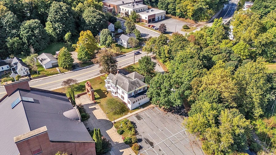 Here's the house! Parking is directly behind the home, and entrance to unit is from ground level, then up the stairs to the main floor. On the left is the church, and on the right, beneath the trees, is a brook and next to that the town athletic fields.