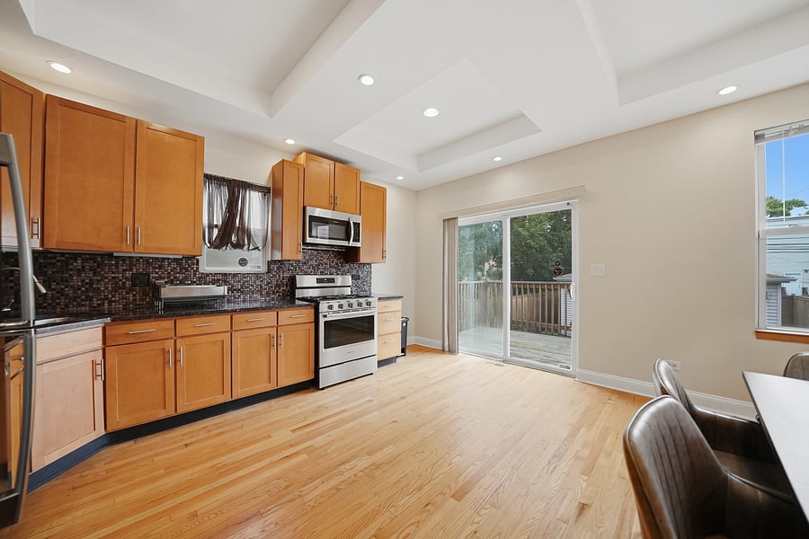 Kitchen: Expansive, fully stocked kitchen and dining space featuring stainless steel appliances, dishwasher, warm wood cabinetry, granite counter space, and seating for 6.