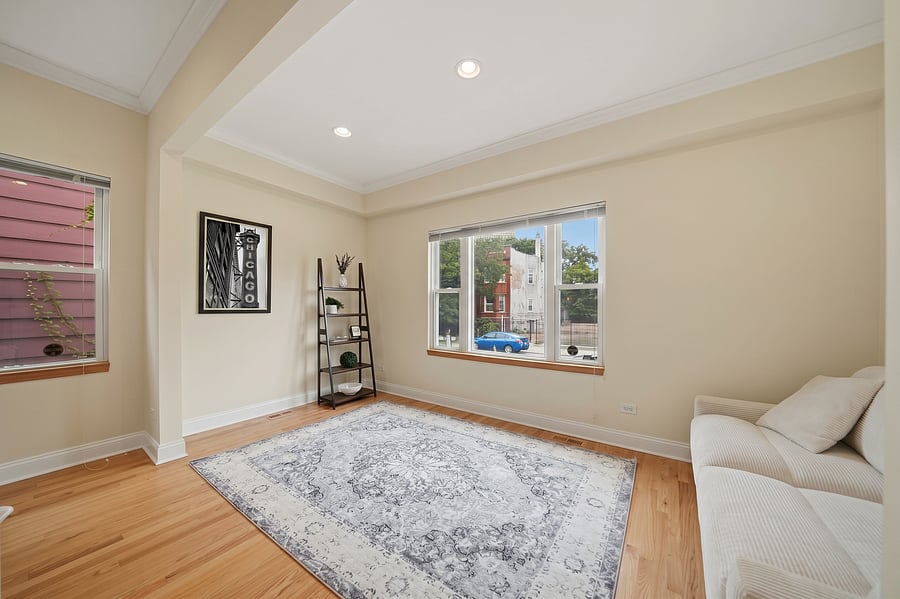 Living Room: Spacious open living layout with huge windows offering vibrant natural light, warm wood floors, and a dedicated space for relaxation.