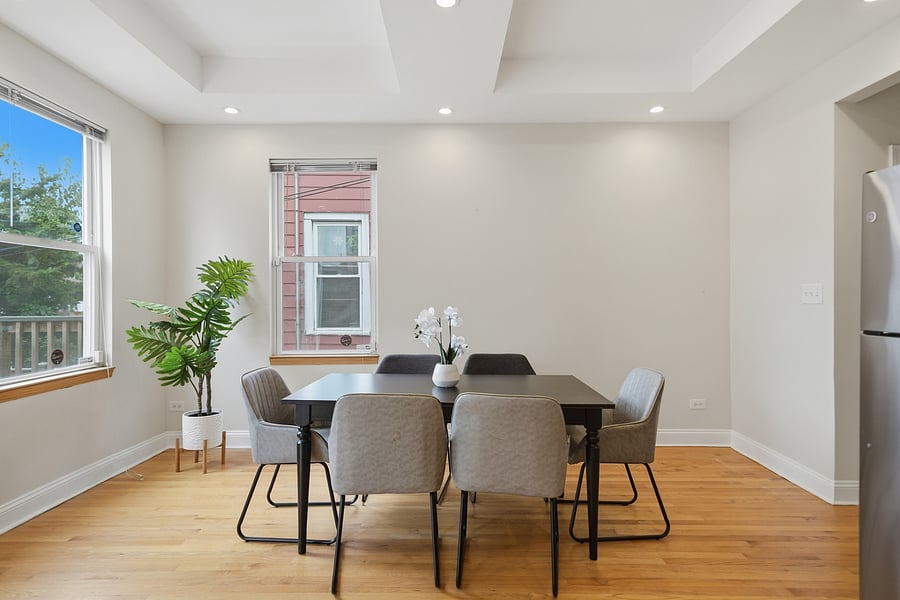 Kitchen: Dedicated dining nook with a modern 6-person table setup and bright windows, located right off the kitchen with seamless access to your private rear deck.