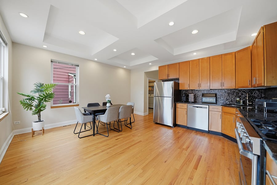 Kitchen: Expansive, fully stocked kitchen and dining space featuring stainless steel appliances, dishwasher, warm wood cabinetry, granite counter space, and seating for 6.