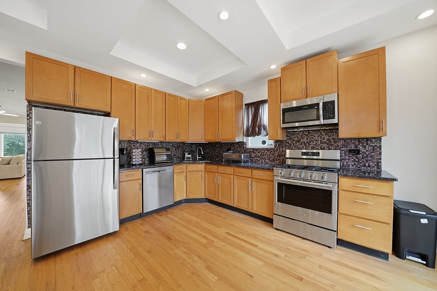 Kitchen: Expansive, fully stocked kitchen and dining space featuring stainless steel appliances, dishwasher, warm wood cabinetry, granite counter space, and seating for 6.