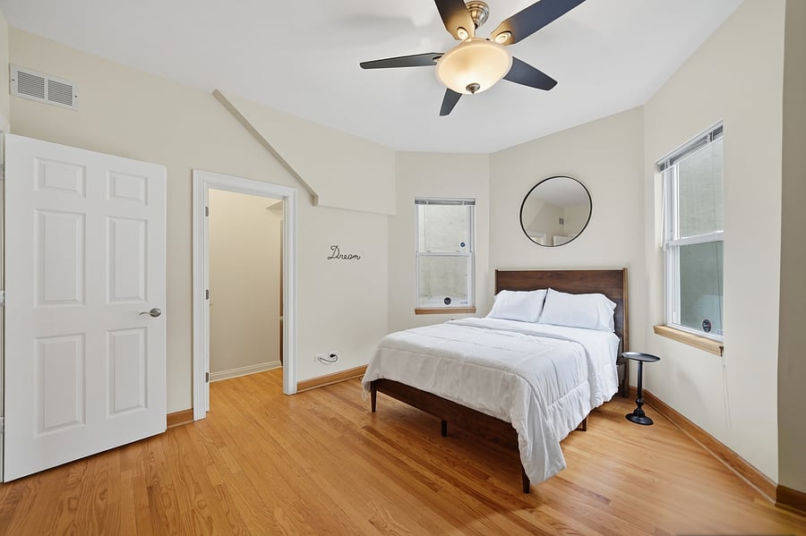 Bedroom: Serene, sunlit bedroom boasting a comfortable full size bed, ceiling fan, and a dedicated executive desk setup-ideal for remote work, telehealth, or studying.