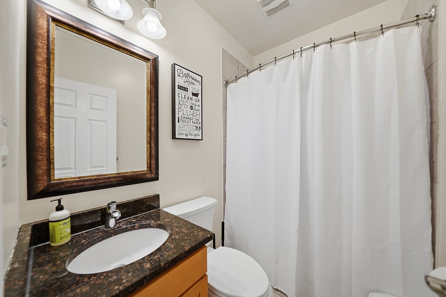 Full Bathroom: Clean, updated bathroom with a dark granite vanity top, full tub/shower surround, stylish mirror lighting, and pristine fixtures. Fresh towels provided!