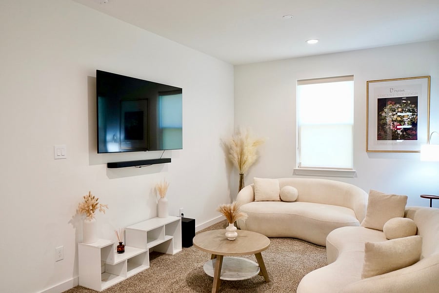 Separate living room with a wall-mounted streaming TV. 2 Gig WiFi for shows and video calls.