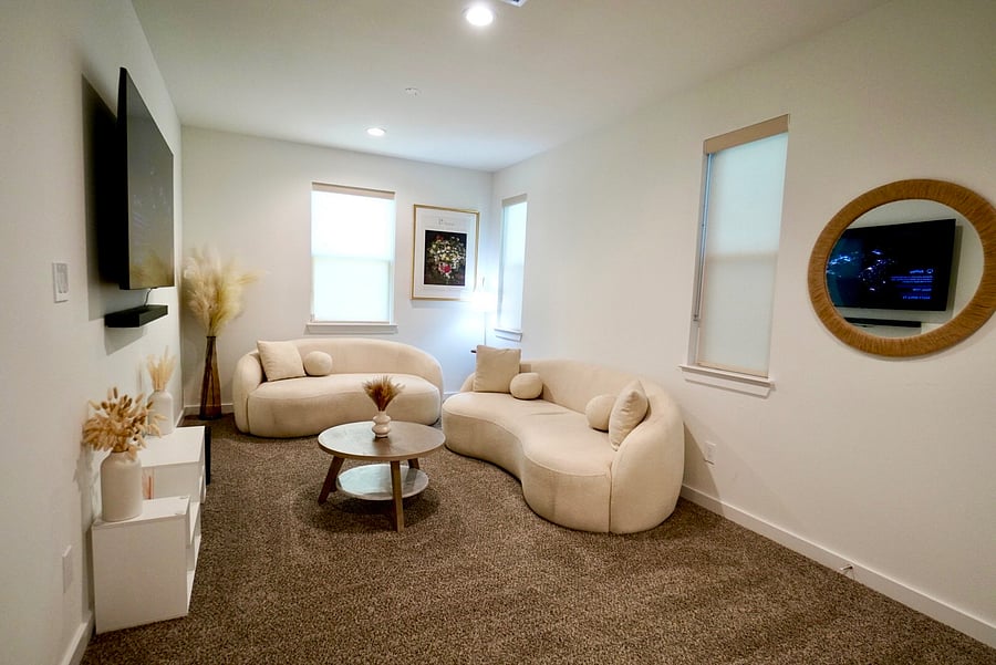 Your own private living room: plush curved sofas, smart TV, and room to decompress.