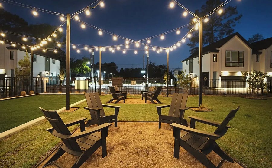 Fire pit lounge under string lights. Perfect for winding down at night.