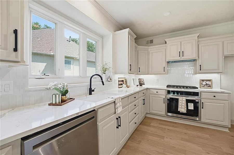 Kitchen range with hood, tile backsplash and stainless dishwasher