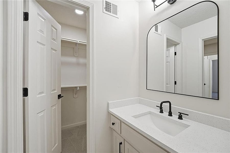 Upstairs bath with quartz vanity and arched mirror
