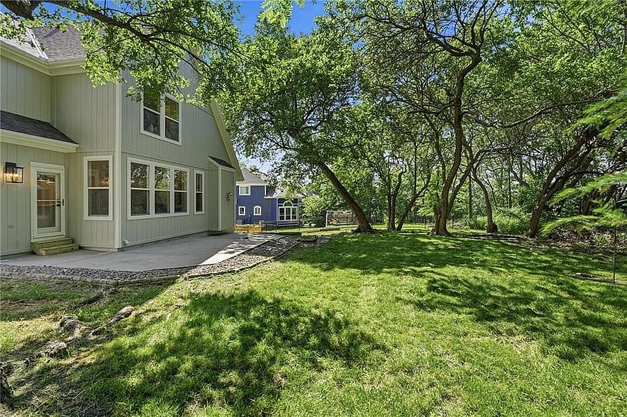 Expansive backyard framed by mature trees