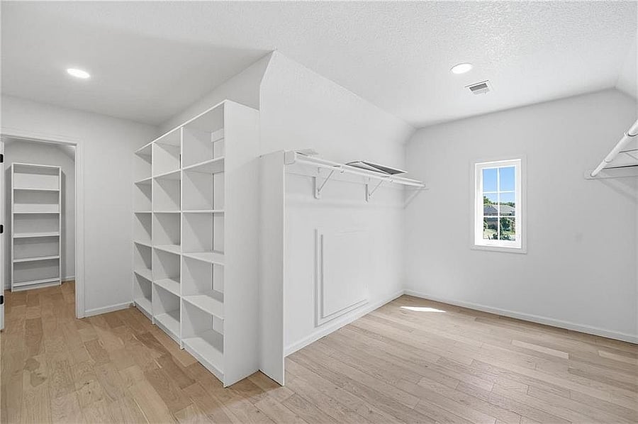 Primary walk-in closet with built-in shelving