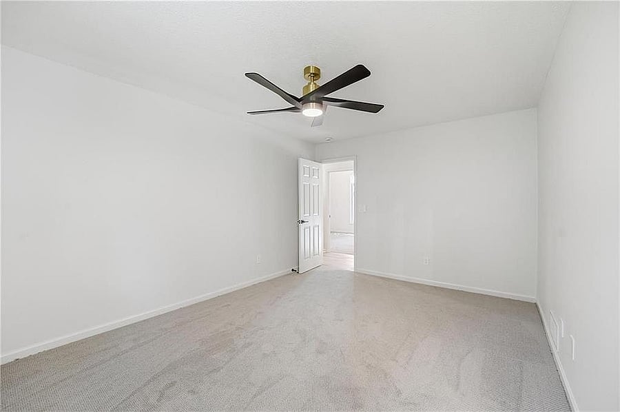 Upstairs bedroom with ceiling fan and carpet