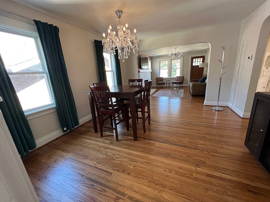 View of the dining and living rooms from the kitchen. The hallway is on the right, and leads to the office (front), steps to driveway and basement (middle), and bedroom (back).