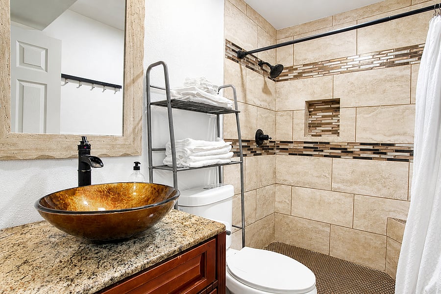 Pamper yourself at the elegant stone vanity featuring a unique, artistic glass vessel sink.