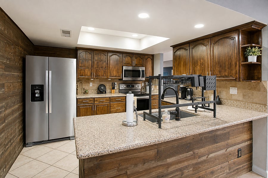 Prep your favorite ingredients easily on beautiful stone countertops surrounded by rich wood accents.