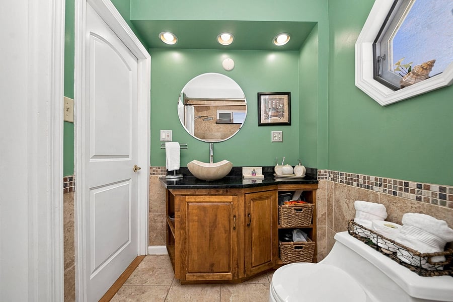Bathroom has granite counter top and stone vessel sink.