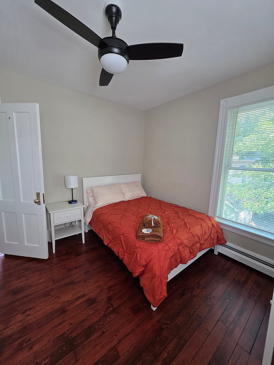 Bedroom overlooking the backyard. fully furnished with bed, nightstand, dresser, light, desk and desk chair.